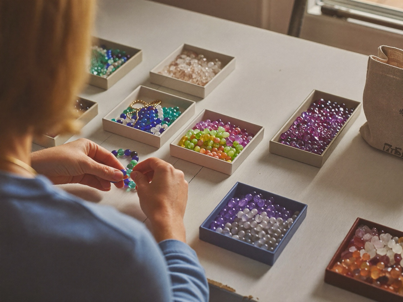 Stringing gemstone beads at the studio table